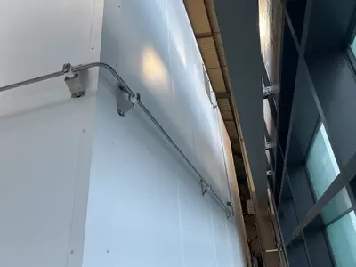 High-pressure stainless pipework routed along the rear wall to feed the wash boom at a logistics facility in Ellistown.